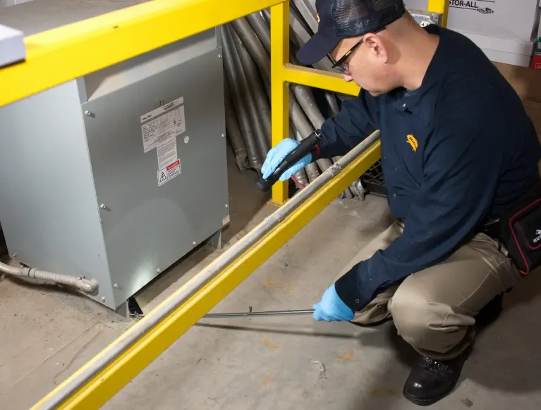 A McCloud Services technician inspecting a commercial business for pests as part of an integrated pest management services (IPM) plan.